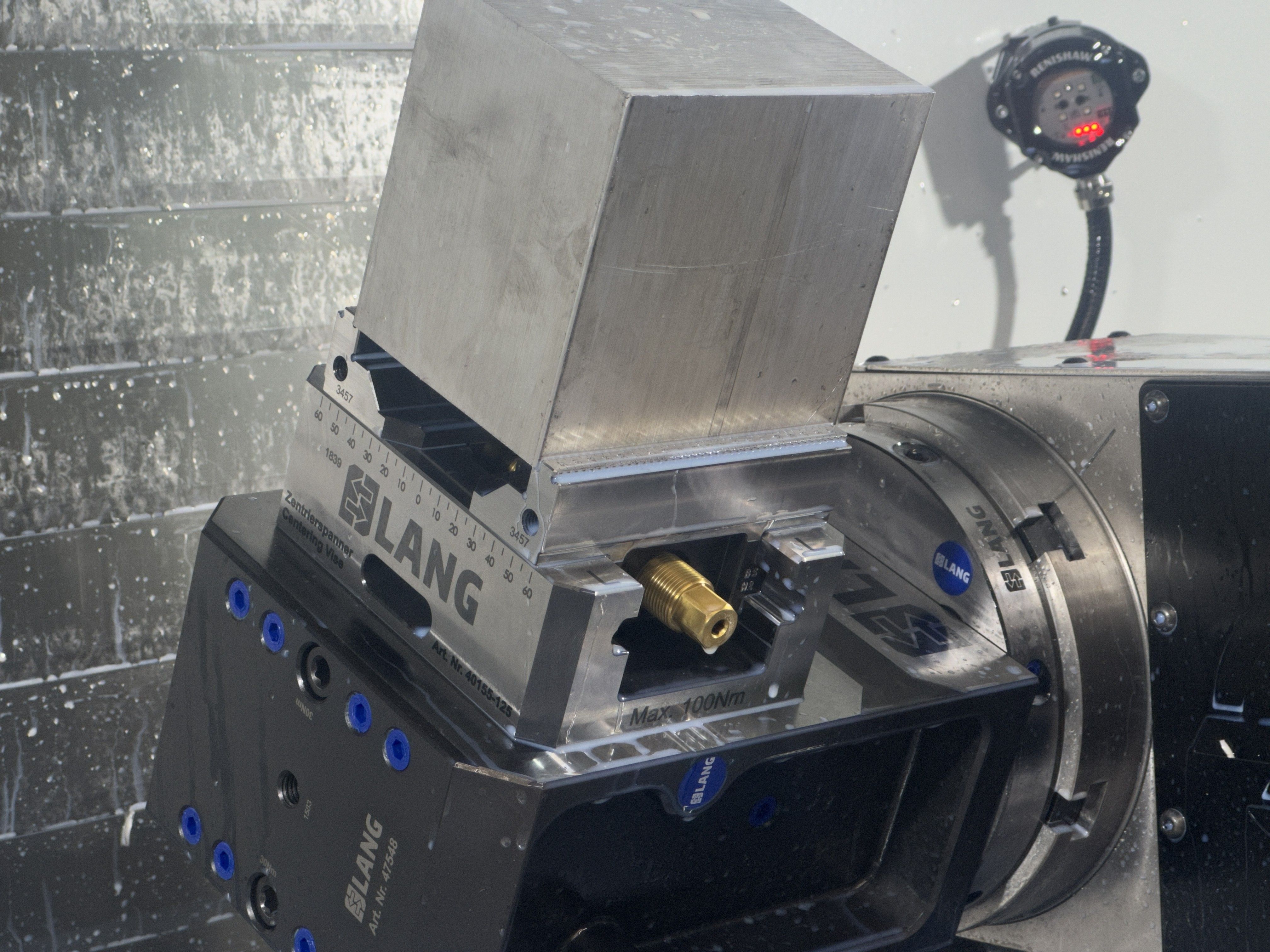 Aluminum billet clamped in a Lang centering vise on the fourth-axis rotary table