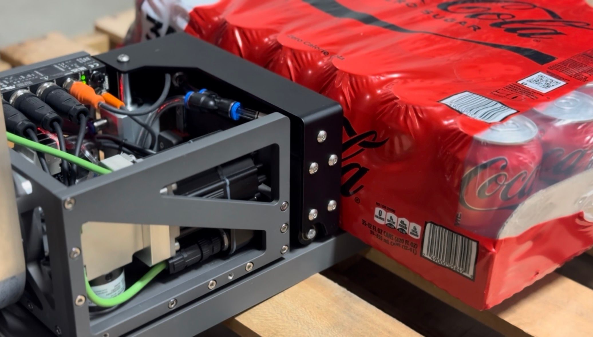 ProPick's pick head alongside a case of canned drinks on a pallet